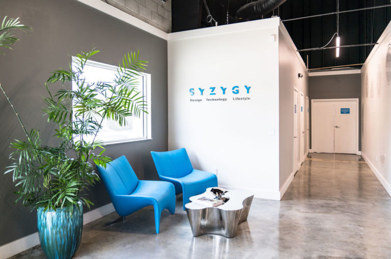 Syzygy Sign on the wall and blue chairs