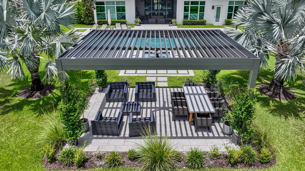 ): An overhead view of a modern pergola, featuring motorized louvered roof panels, shading a dual-zone outdoor space.