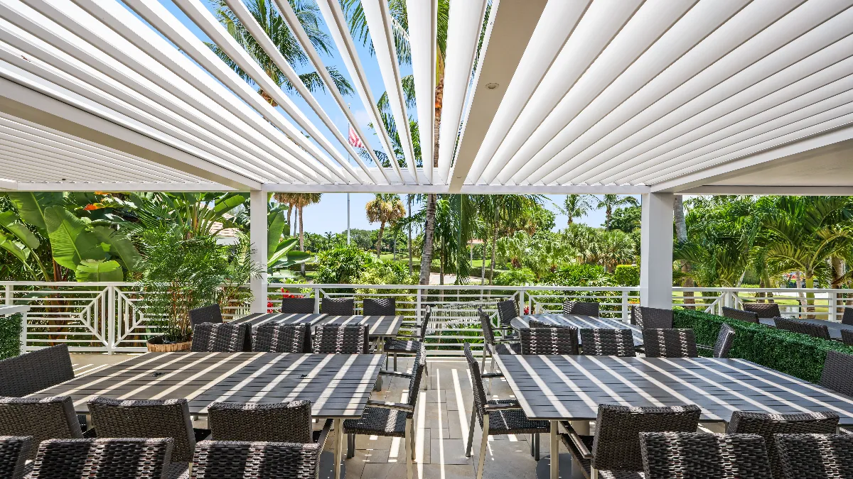 Open-louver pergola at Jonathan’s Landing casts patterned shade over the newly revitalized outdoor dining area.