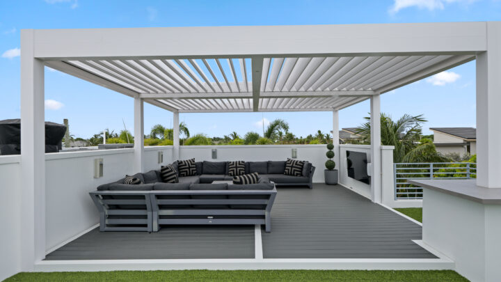 Modern rooftop with a white waterproof louvered pergola and outdoor seating in South Florida.
