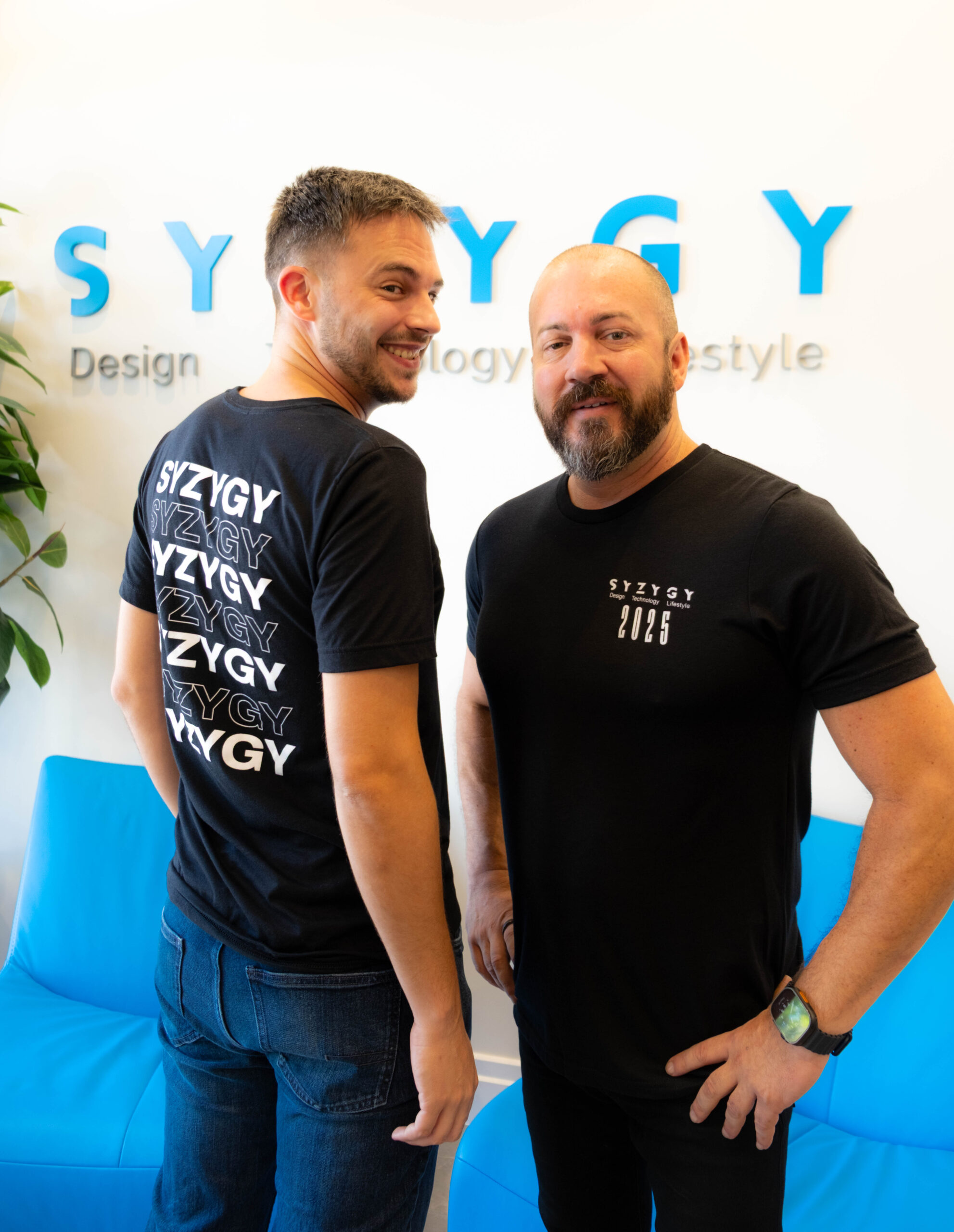 SYZYGY Global team members wearing custom 8th anniversary shirts at the Delray Beach office.