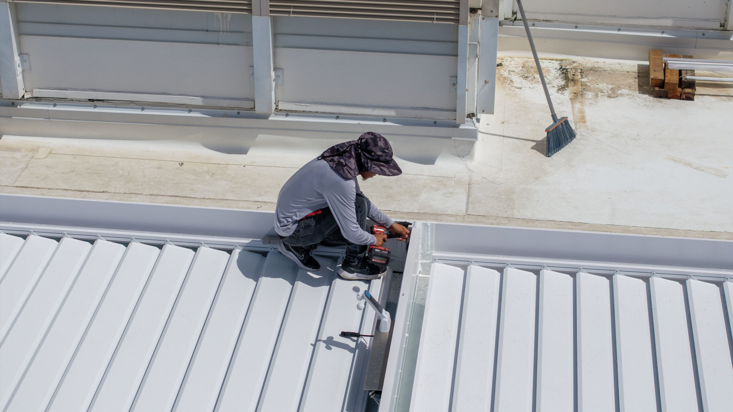 Technician installing R-Blade pergola louvers at Royal Poinciana apartment complex in Palm Beach.