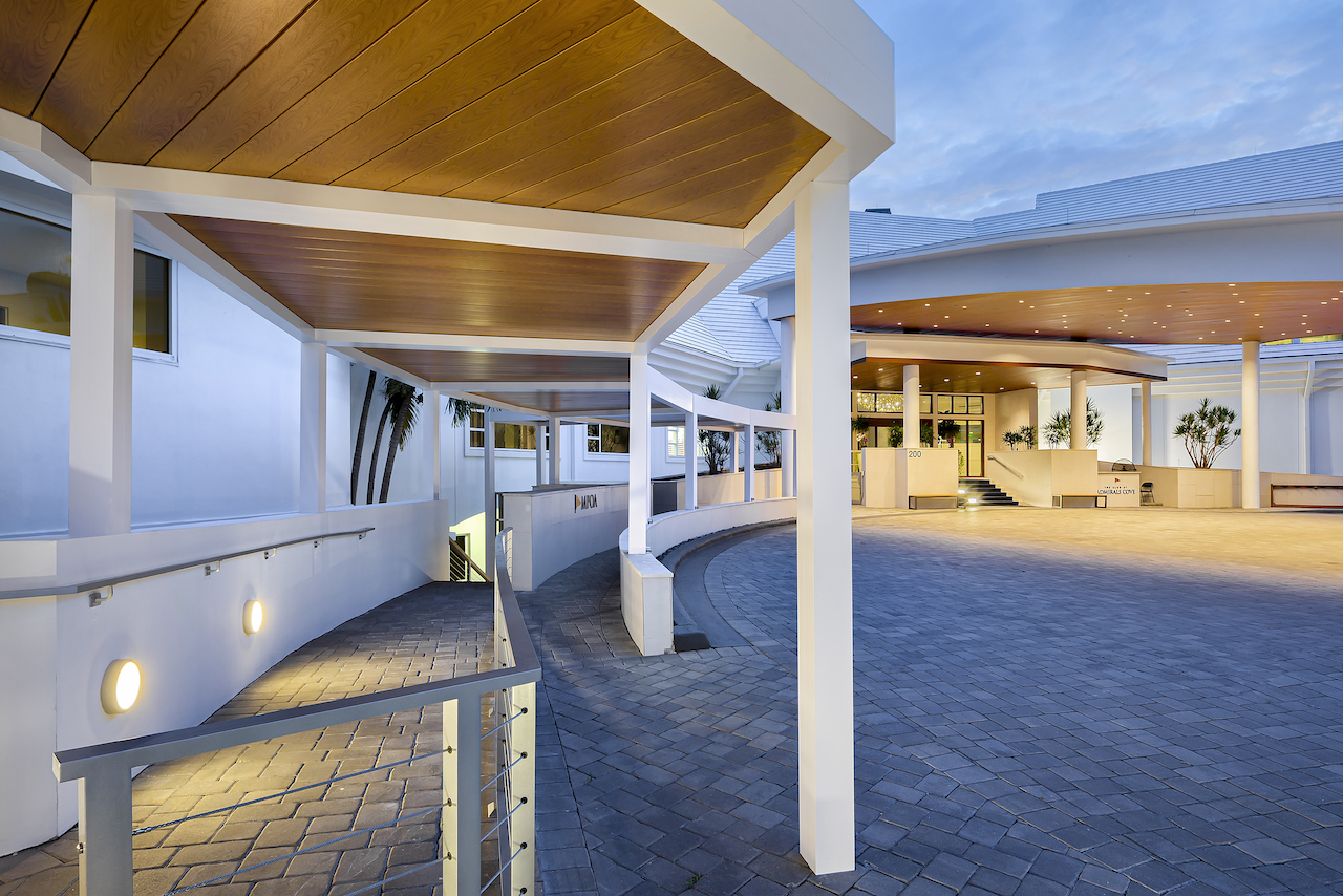 Wood grain aluminum pergola covers the entry walkway at The Club at Admiral’s Cove, blending luxury with durable design.