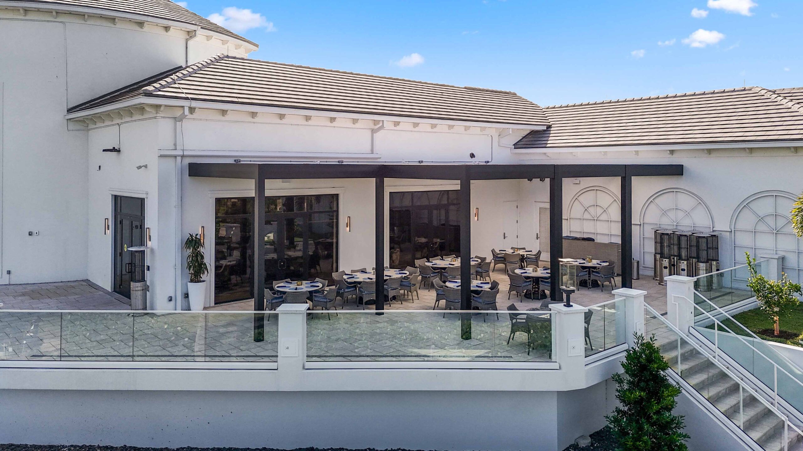Luxury outdoor dining space with black R-Blade pergola at Broken Sound Club in Boca Raton, Florida.