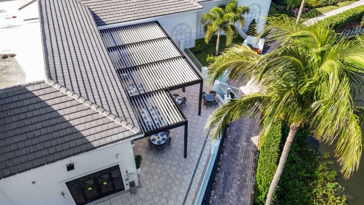 Overhead view of four R-Blade pergolas with white louvers at Broken Sound Club, creating shaded outdoor dining space.