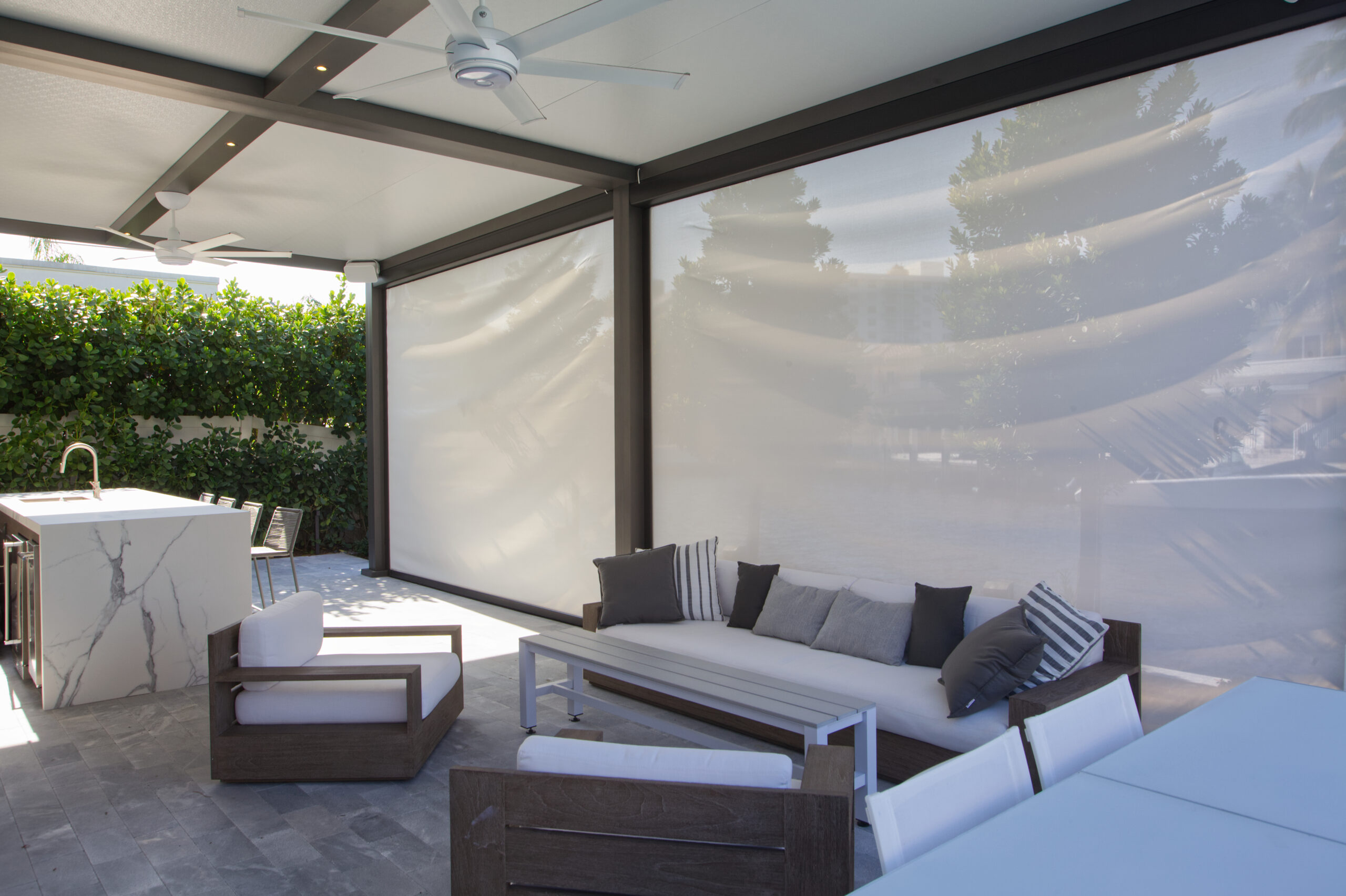 Modern enclosed pergola with retractable screens for luxury outdoor living in South Florida.