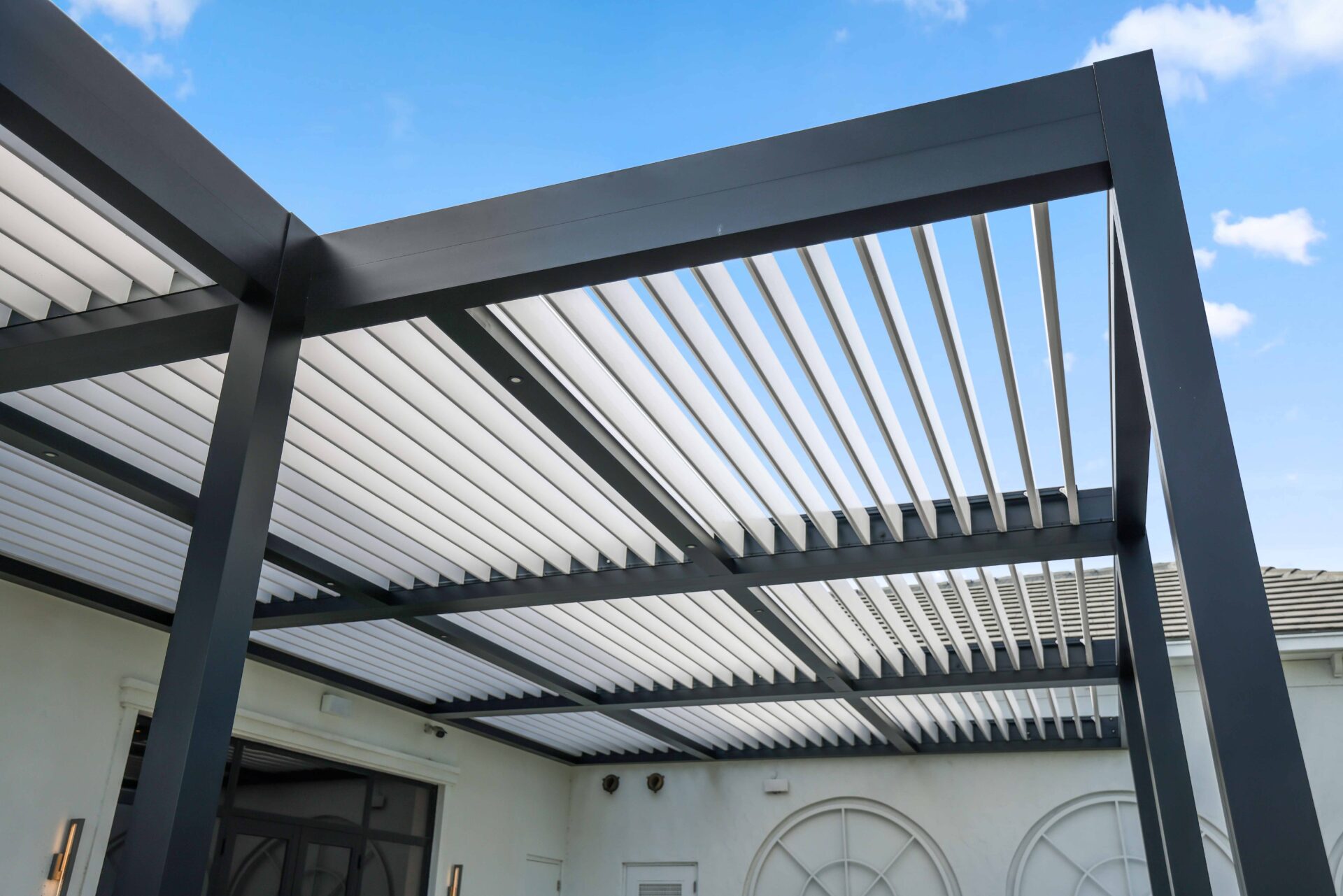 Close-up of black R-Blade pergola frame and white louvers at Broken Sound Club, showcasing clean lines and concealed hardware.