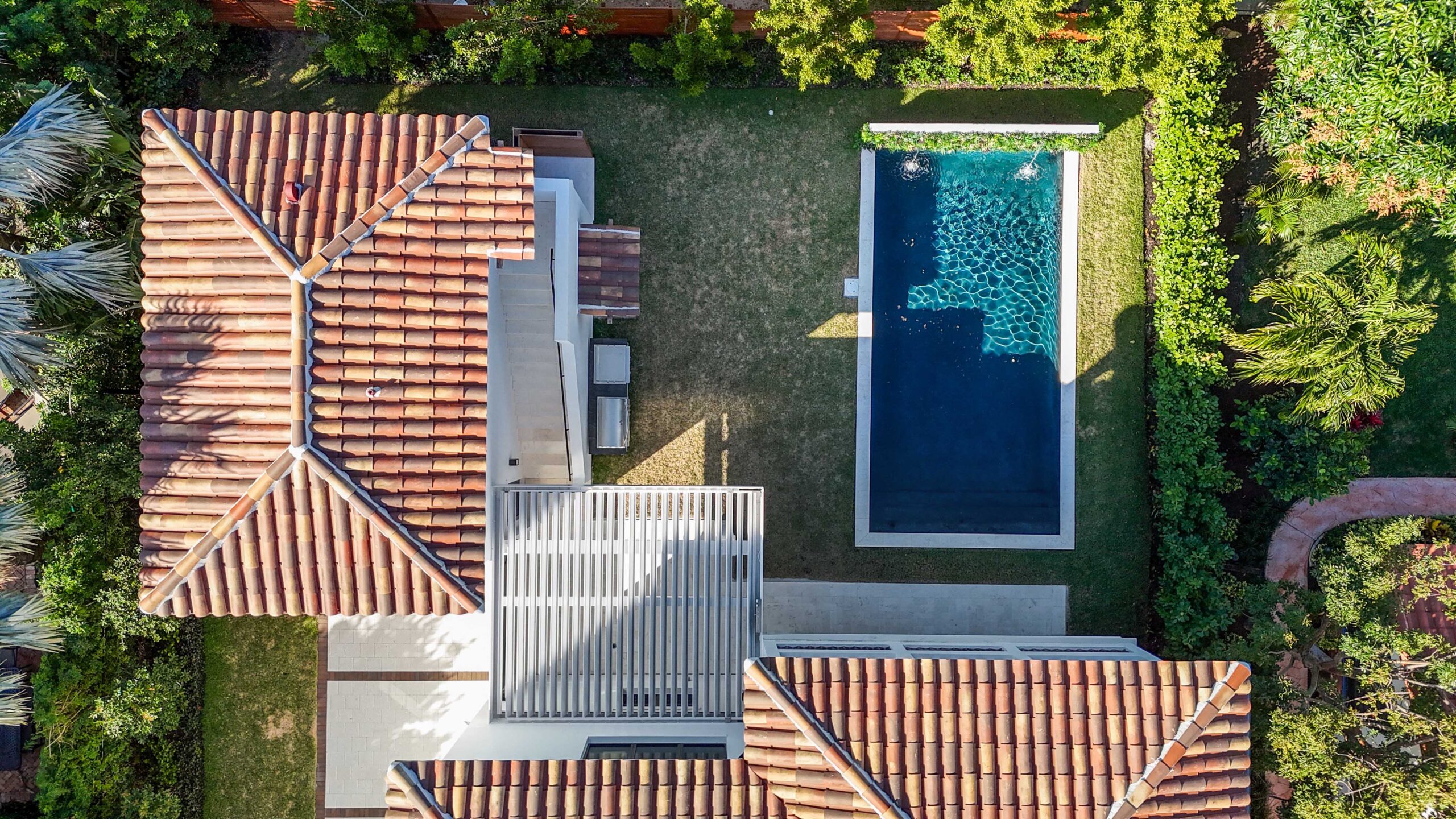 Aerial view of Mediterranean-style home with terracotta roof, modern pergola, and backyard pool in South Florida.