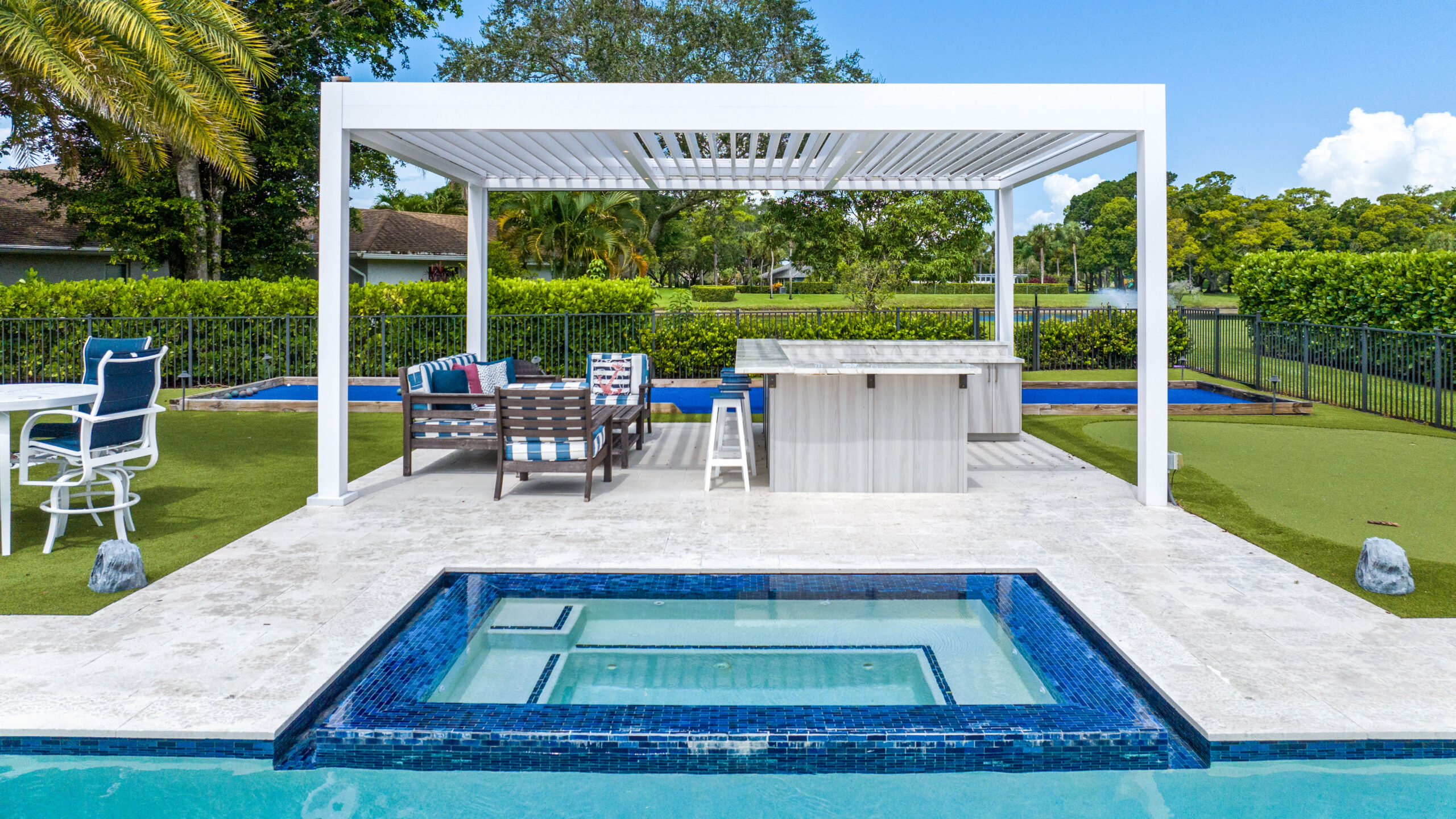Accessible outdoor living with an R-Blade pergola over a poolside kitchen and lounge in South Florida.