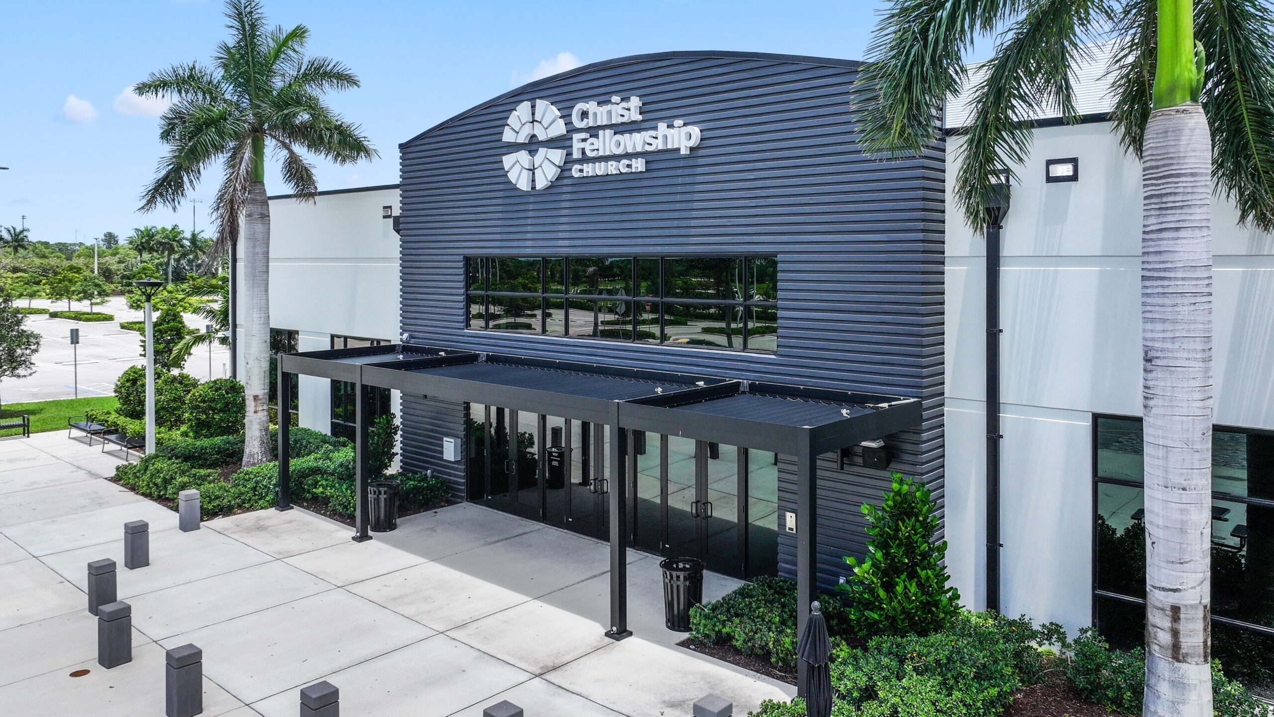 Church entrance with black pergola providing shaded walkway and modern architectural detail at Christ Fellowship Church.
