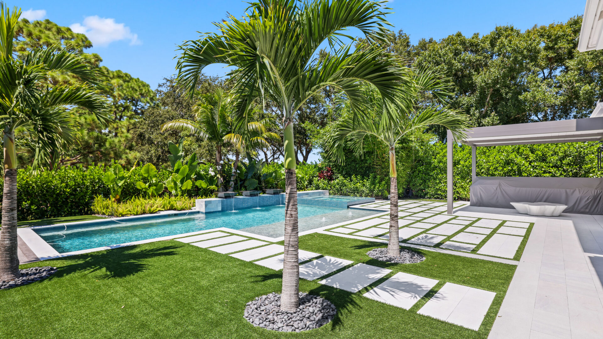 South Florida outdoor living design with modern pergola, palm-lined pool, and landscaped backyard for luxury coastal living.